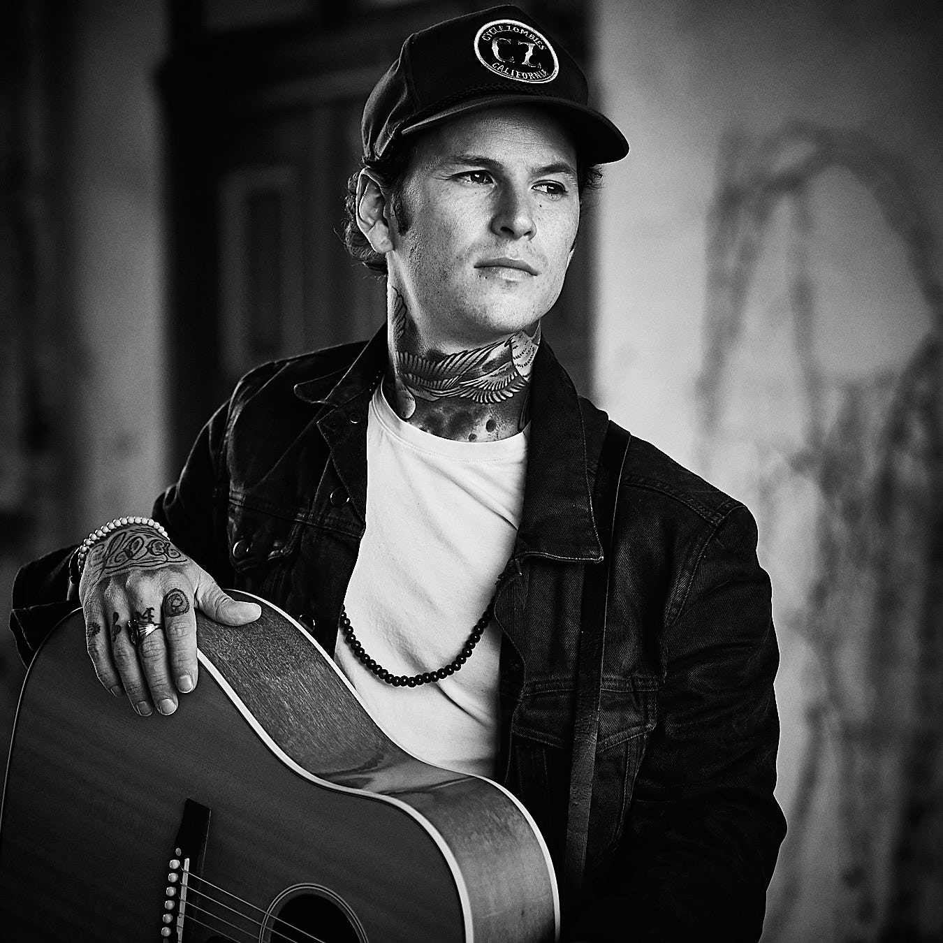 musican holding his guitar. he is looking to the right. maybe he is thinking of his next big hit. picture is in black and white